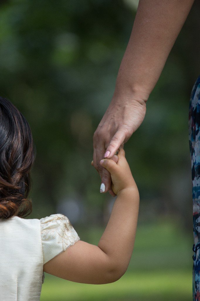 Adult and child holding hands, symbolising guidance and care
